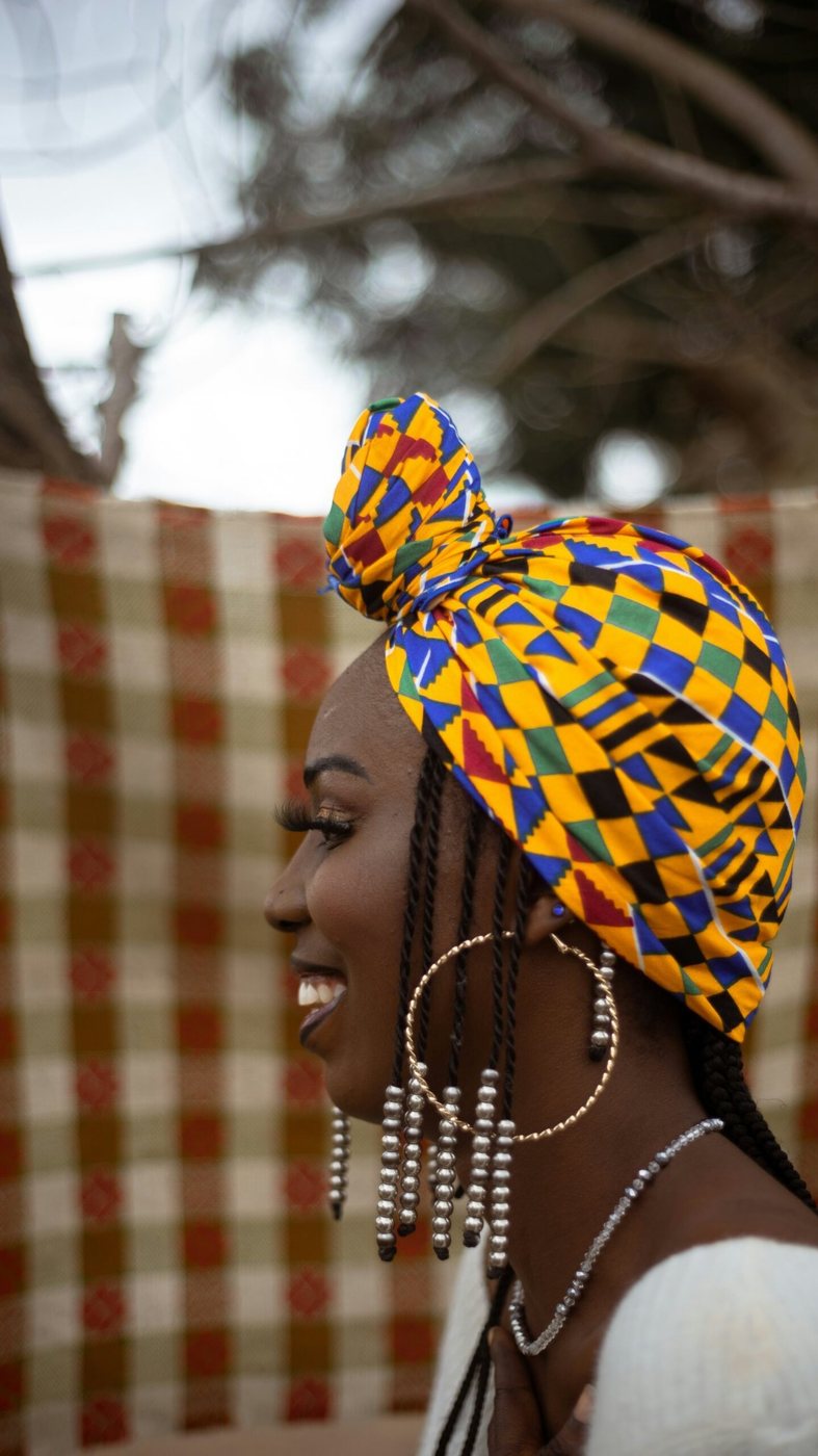 Smiling woman wearing a vibrant African-print headwrap